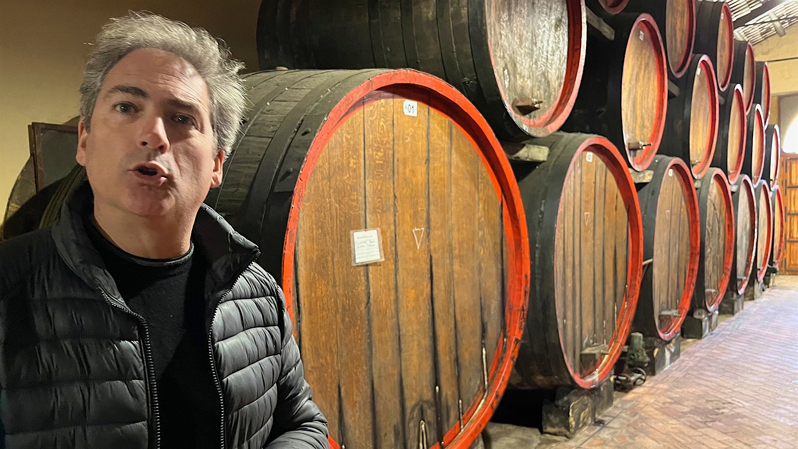 Renato De Bartoli in front of a set of old barrels, explaining how the winery uses Marsala's traditional "in perpetuum" system to create its Vecchio Semperi wine